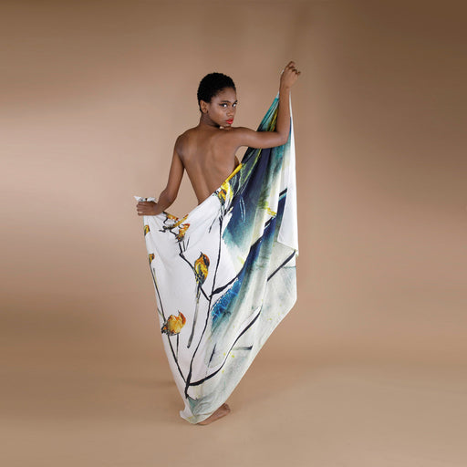 A global small size model draped in organic aloe vera fabric scarf, printed on white base with multicolor leaf and birds sitting on the branches. 