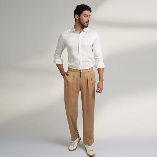 a medium size model wearing beige color trouser made from organic lotus silk fabric. the pant is a basic straight fit with 2 pleats and turn up bottom.