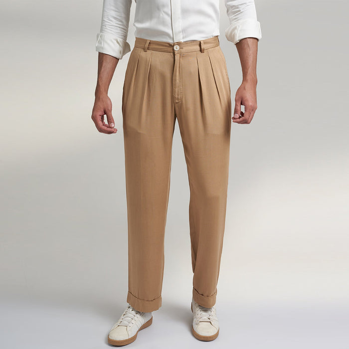 a medium size model wearing beige color trouser made from organic lotus silk fabric. the pant is a basic straight fit with 2 pleats and turn up bottom.