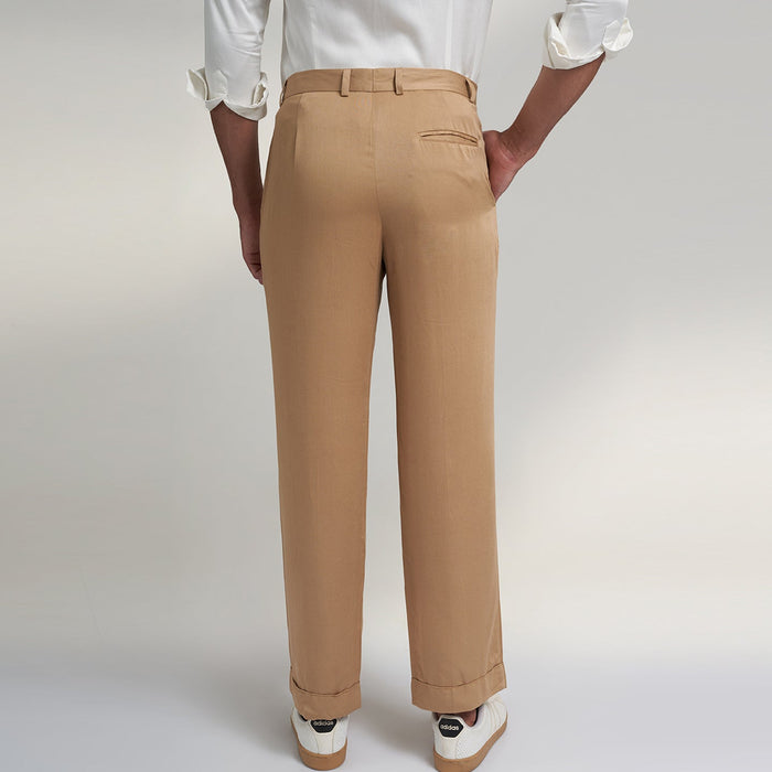 a medium size model wearing beige color trouser made from organic lotus silk fabric. the pant is a basic straight fit with 2 pleats and turn up bottom.