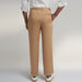 a medium size model wearing beige color trouser made from organic lotus silk fabric. the pant is a basic straight fit with 2 pleats and turn up bottom.