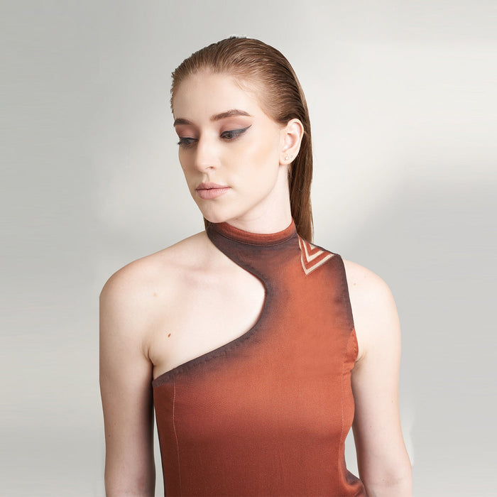 A global medium size model wearing a maroon wine dress with an asymmetrical neckline and a cut-work on left shoulder highlighted with ombre edges all over; crafted in organic lotus stem fabric.