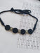 Black choker necklace with round charms in silver and black on white backdrop